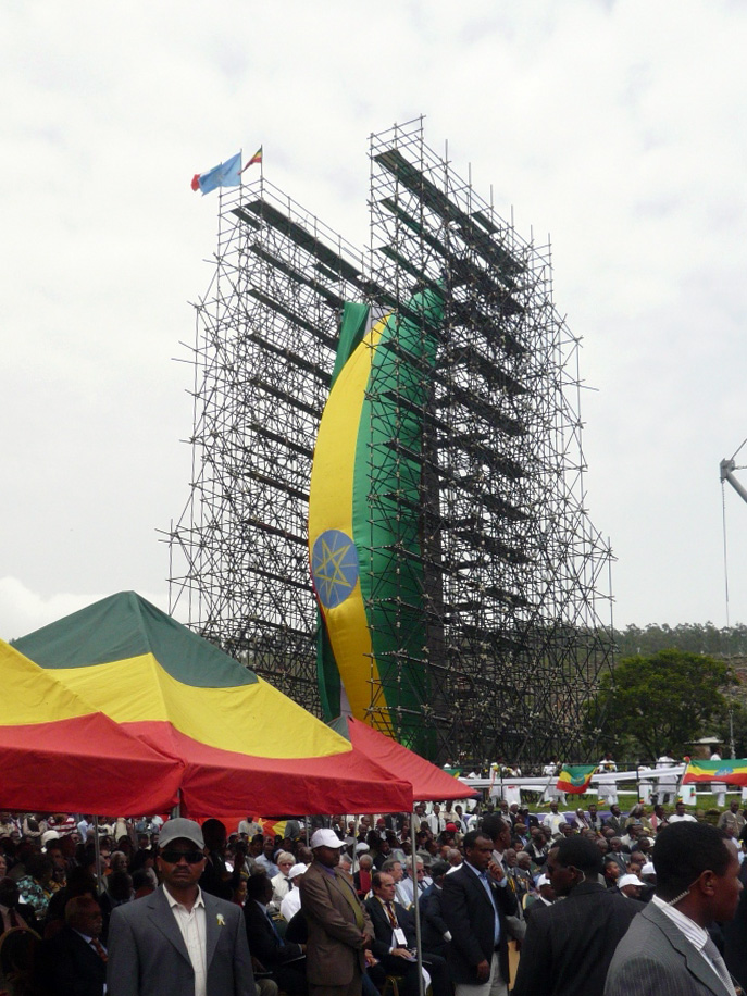 Crowds and Ethiopian-coloured tents beside the scaffolded, draped Aksum Obelisk at its inauguration on 4 September 2008.