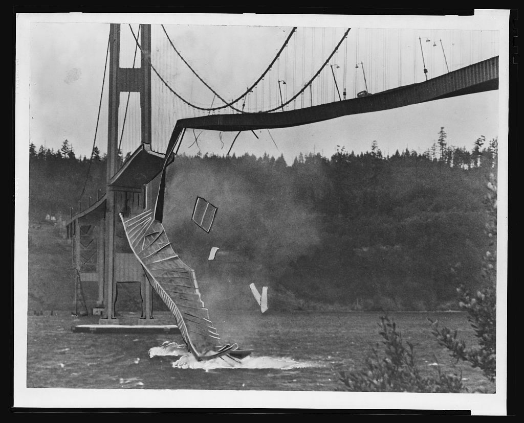 The Tacoma Narrows Bridge deck twisting and breaking apart above Puget Sound during its collapse on 7 November 1940.